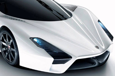View of the front end of a white, futuristic concept car with blue headlights